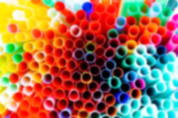 Blurred colored background made of plastic tubes for cocktails and drinks