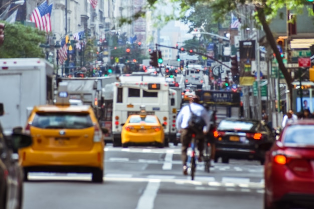 ニューヨークでの生活の熱狂的な活動のぼやけた概念。車、公共交通機関、自転車、歩行者、標識、旗。混雑した都市と交通の概念。マンハッタン、ニューヨーク。我ら