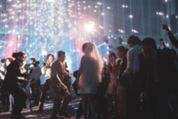 Blurred concept happy groom and bride dancing at wedding party with guest.