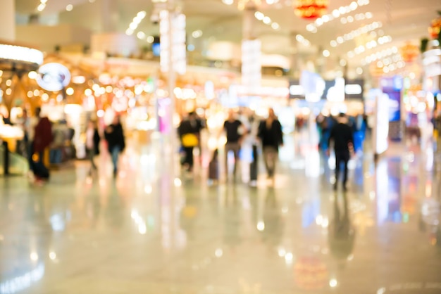 Blurred crowd of people walking in airport hall or shopping mall