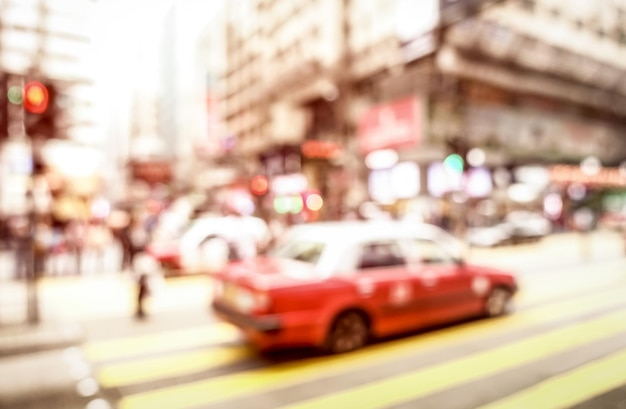 부드러운 분홍색 파스텔 필터가 있는 얼룩말 횡단에 있는 빨간색 택시의 흐릿한 추상 배경