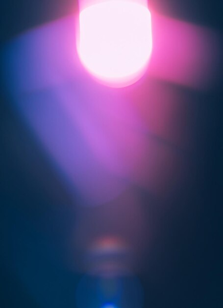 Blurred defocused bright light lens flare shiny spots dark background