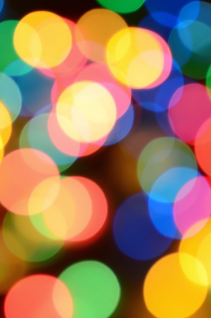 Photo blurred festive colorful lights over black useful as background. all main colors included.