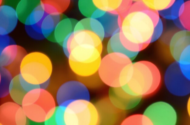 Blurred festive colorful lights over black useful as background. 