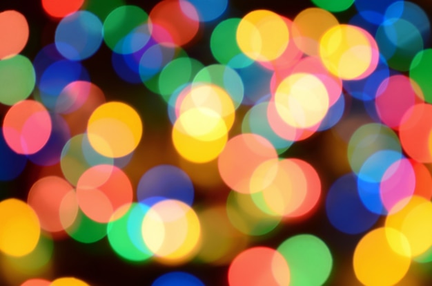 Blurred festive colorful lights over black 