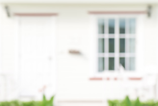 Blurred front view of white house with door and window, for background