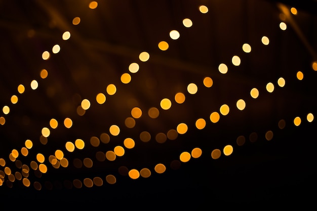 Photo blurred golden lights on black background. festive pattern for your design.