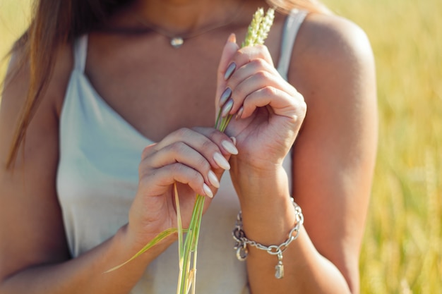 Foto le mani vaghe si chiudono su, donna con bello manicure, vestito d'argento, fondo del campo