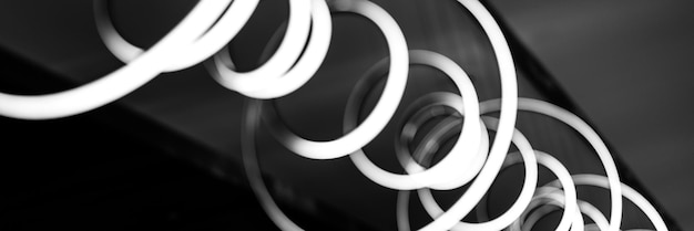 Blurred hanging lamp bulb in the form of rings blur abstract lighting modern pendant electricity round lamps chandelier glowing gray dim light inside a room tinted in black and white banner