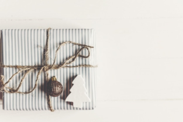 Размытое изображение рождественских подарков с украшениями и игрушками на белом деревянном фоне вид сверху пространство для текста с рождеством концепция сезонные поздравительные открытки
