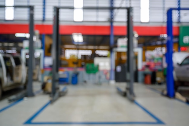 Immagine sfocata di ascensore elettrico per auto in officina installato su un pavimento epossidico in un servizio di fabbrica di automobili centro servizi di riparazione auto sfoca lo sfondo per l'industria automobilistica