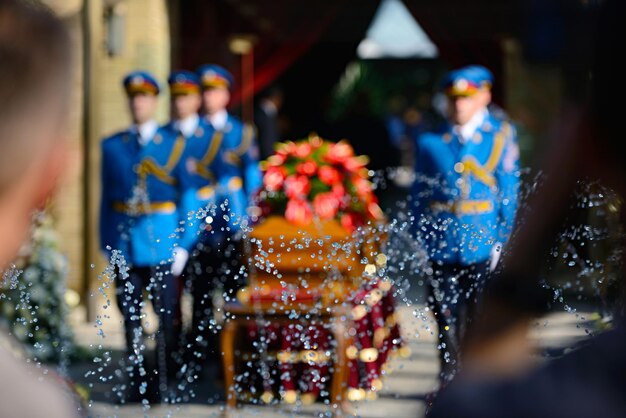 Foto immagine sfocata della guardia d'onore in piedi accanto a una bara a un funerale