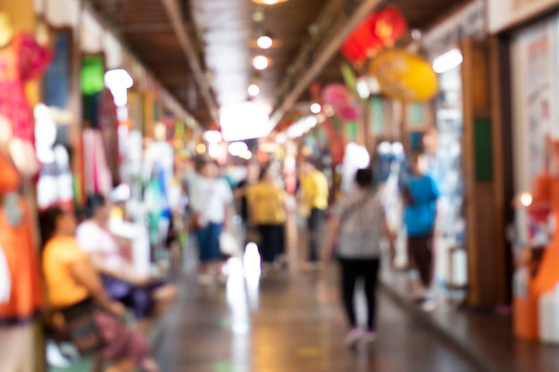 Blurred image of a market with many people and vendors