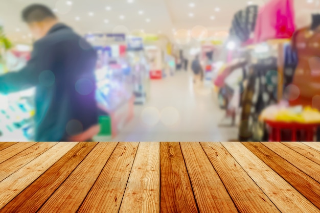 blurred image wood table and abstract department store shopping mall center and people background