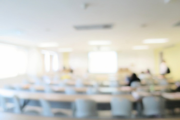 Photo blurred of lecture room or meeting room with long table, chairs, projector, and big window. education.