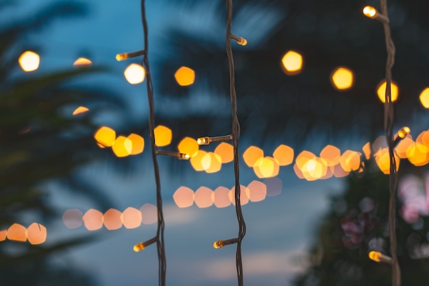 Photo blurred light bokeh with coconut palm tree background on sunset