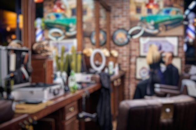 blurred loft stylish barbershop interior with wooden countertops and leather chairs