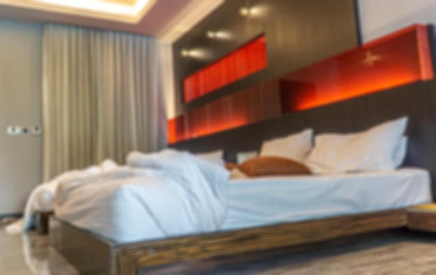 Blurred the luxury bedroom that opens a window king bed with\
white linens and pillows interior with garden view window bed with\
white bed linen and curtains in the morningxa