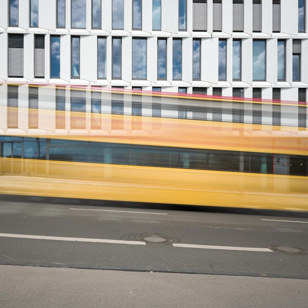 Foto movimento sfocato dell'autobus sulla strada contro gli edifici