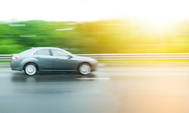 Blurred Motion,car moves very fast speed on highway with green tree