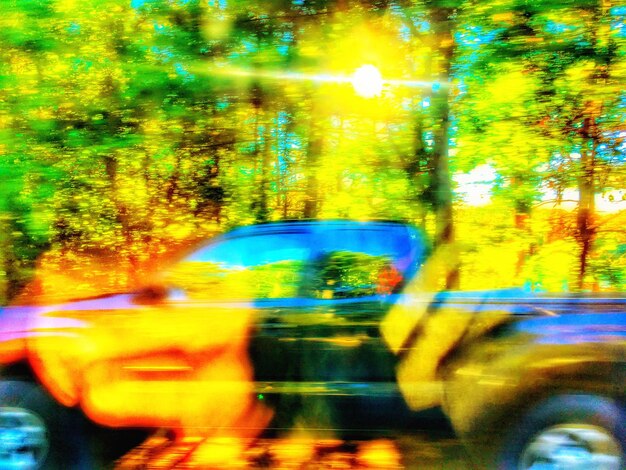 Blurred motion of car on road seen through wet window