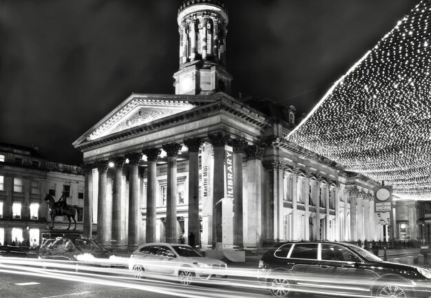 Photo blurred motion of cars on road against building at night