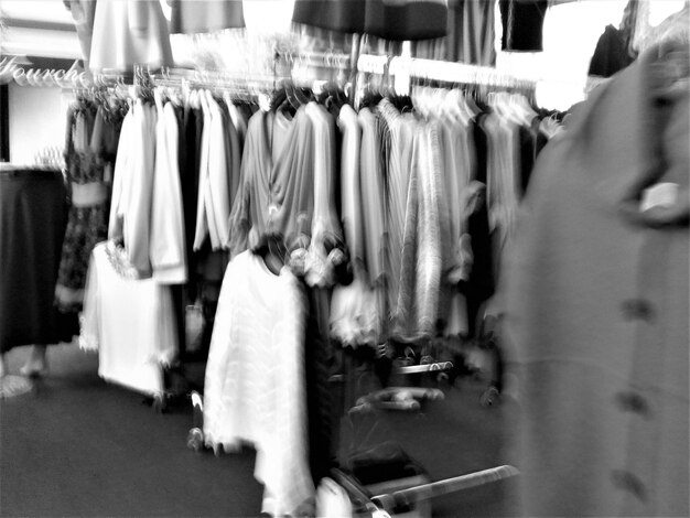 Foto movimento sfocato dei vestiti appesi in negozio per la vendita