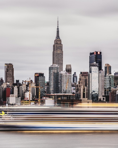 Photo blurred motion of cruise in river against buildings