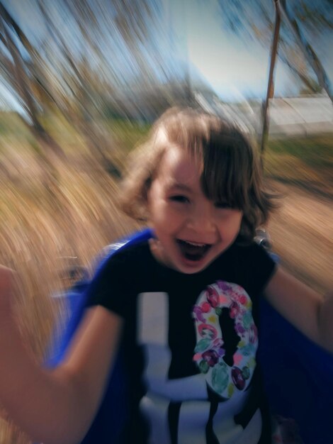 Blurred motion of girl sitting on swing in playground