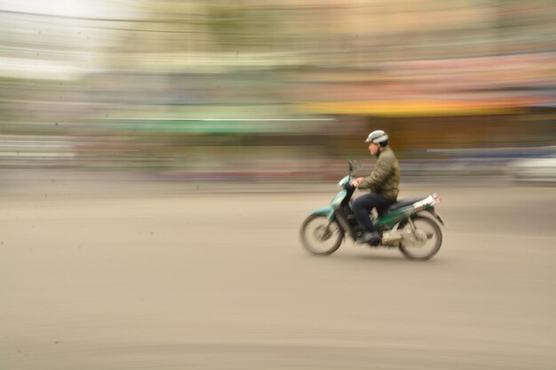 Photo blurred motion of man riding motorcycle on road