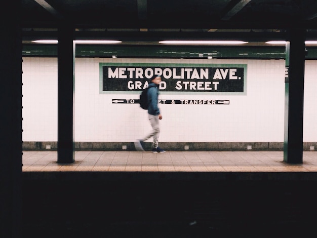 Foto movimento sfocato di un uomo che cammina sulla piattaforma della stazione ferroviaria