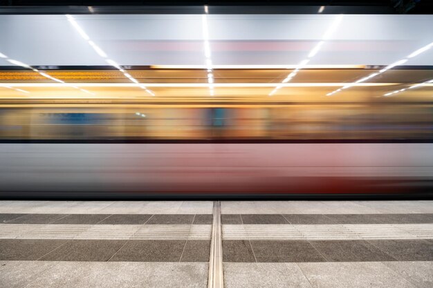 写真 鉄道駅のプラットフォームで列車の動きがぼやけている