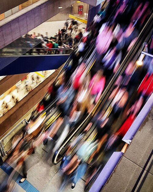 Foto movimento sfocato delle persone sulle scale mobili della stazione della metropolitana