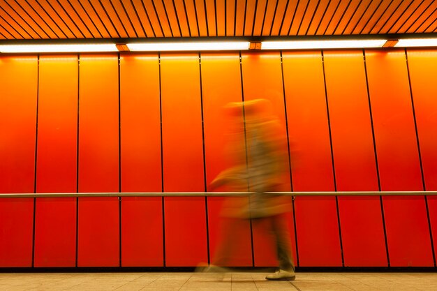 Foto movimento sfocato di persone che camminano in arancione illuminato