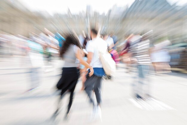 Blurred motion of people walking on road in city