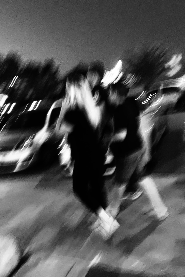 Photo blurred motion of people walking on street at night