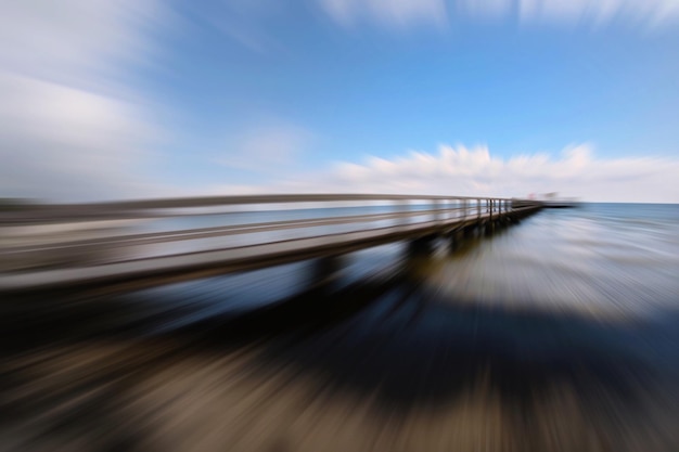 Photo blurred motion of pier against sky at beach