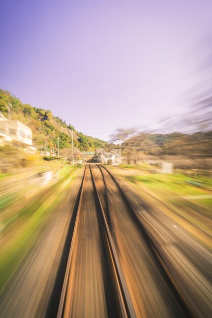 Foto movimento sfocato dei binari ferroviari sulla strada contro un cielo limpido