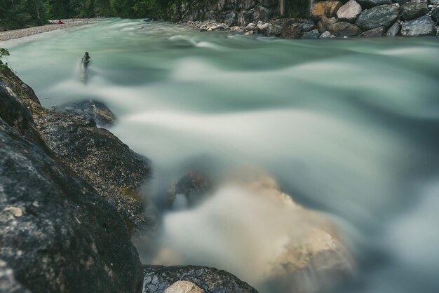 Photo blurred motion of river flowing amidst rocks