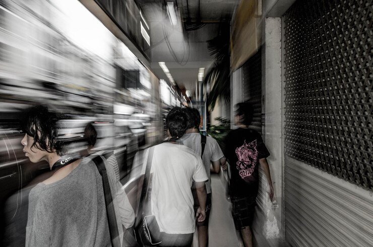 Photo blurred motion train by people at railroad station platform