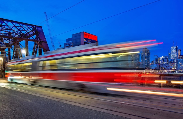 Blurred motion of train in city against blue sky