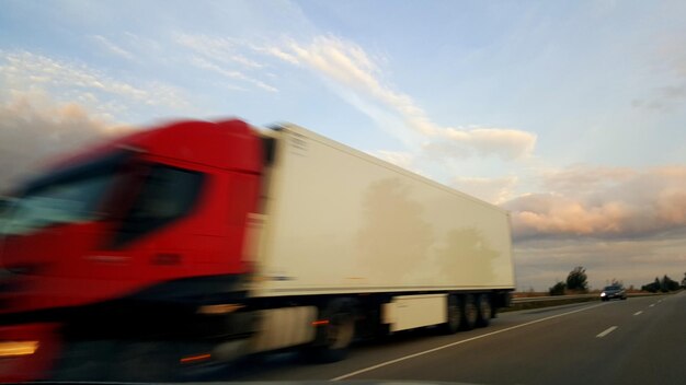 Foto movimento sfocato del camion sulla strada contro il cielo