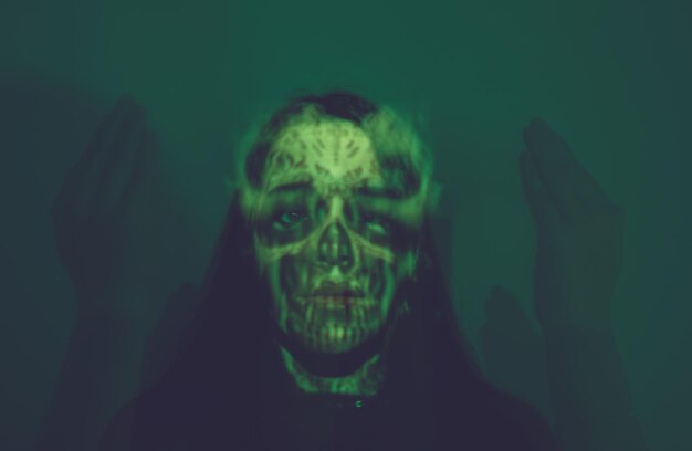 Photo blurred motion of woman with spooky make-up against colored background