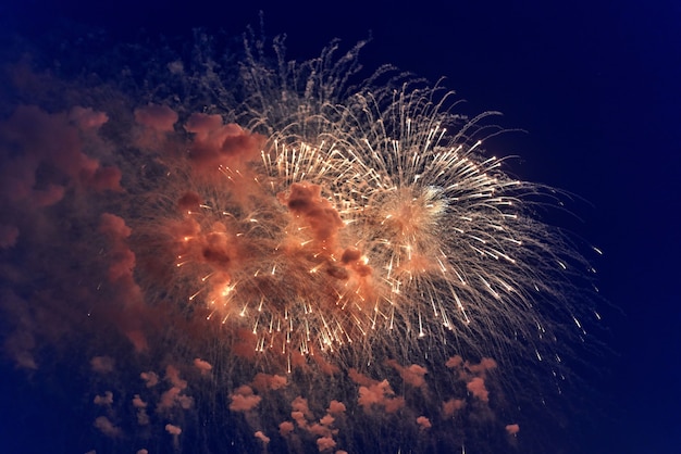 Blurred multicolored fireworks lights against the dark night sky