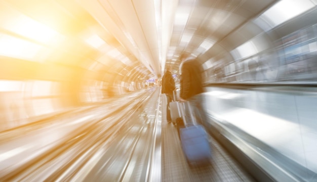 Blurred passengers using a skywalkstaircase at a airport