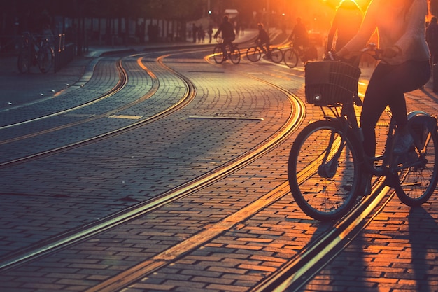 Blurred of people riding bicycle during the sunset in the city of Bordeaux in vintage style and grain texture with copy space