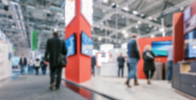 blurred people standing and walking on trade fair booths, intentionally blurred post production. ideal for websites and magazines layouts