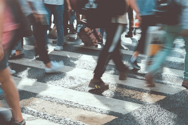 Blurred people walk the sunny city toned