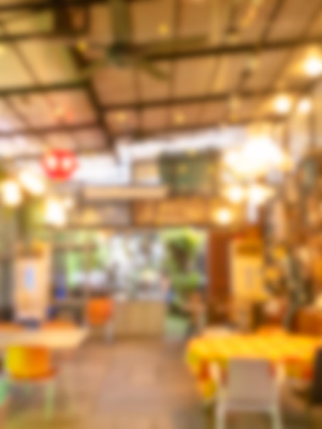 Blurred photo of interior restaurant view background with dining table set chairs blurry cafe retro style defocused cafeteria backgrounds vertical style Lighting decoration indoor cafeteria