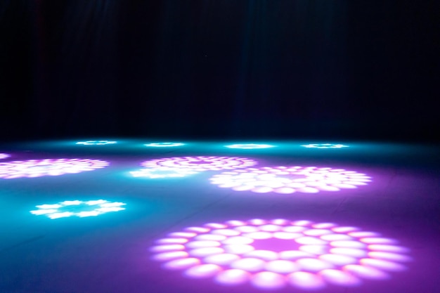 Blurred rays of light on disco floor pink blue neon searchlight lights laser lines and lighting effect night empty stage in studio with neon reflections scene of dark abstract space background